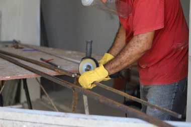 Öğütücüyle metal kesen bir işçi