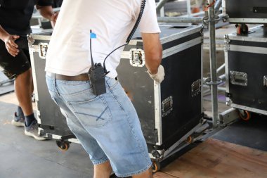 Dışarıdaki sahnelerde, çantalı ve arabalı canlı müzik performansları için ekipmanla çalışan insanlar