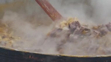 Locro 'yu büyük bir tencerede pişiren birinin videosu. Geleneksel Arjantin yemekleri