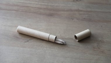 Siyah grafit çevre dostu kalemler. Tahta bir masanın üzerindeki karton kutunun içinde.