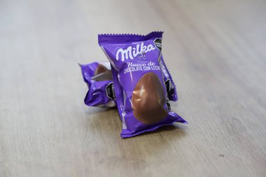 Milka marka çikolatalı Paskalya yumurtası ahşap bir masada.
