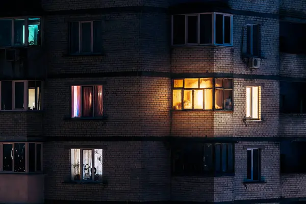 Warm light from the balcony window at evening time cozy atmosphere photo of brick residential house facade