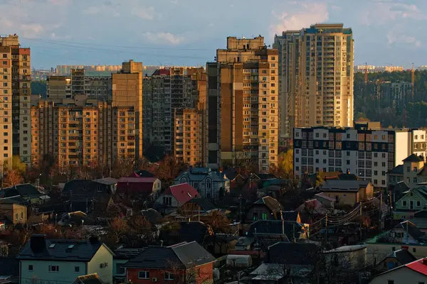 stock image Cityscape at sunset. An area with massive multi-storey buildings in Eastern European style. In front of the houses is a private sector.