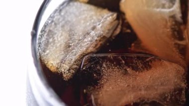 Buzlu kola kokteyli. Üst Manzara. Buz küplerinin bir bardakta yavaşça dönüşünü yakından görmek. Baloncuklar çıkıyor. Klasik viski, rom kokteyli. Soğuk, ferahlatıcı içecek.