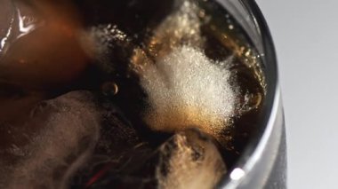 Buzlu kola kokteyli. Üst Manzara. Buz küplerinin bir bardakta yavaşça dönüşünü yakından görmek. Baloncuklar çıkıyor. Klasik viski, rom kokteyli. Soğuk, ferahlatıcı içecek.