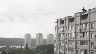 Şehirde fırtınalı bir hava var. Şiddetli rüzgârlı, yağmurlu havalarda bir apartman dairesine bakın. Bulutlu gri gökyüzü. Aşırı hava koşulları.