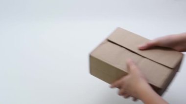 Adamın elleri, içinde kırmızı kurdele olan beyaz bir taşın teslimatı için bir karton kutuyu açıyor. Sahte teslimat konsepti. Yanlış dağıtım kavramı.