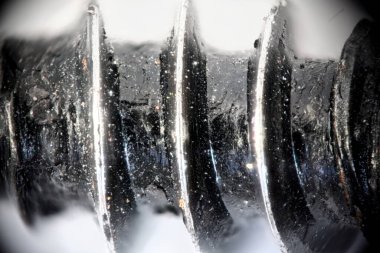 Cıvata ipliği kenar görünümü detaylı. Koyu renk cıvatanın beyaz arka plandaki ipliğinin son derece yakın plan görüntüsü. Tamir işleri. Soyut arkaplan, duvar kağıdı