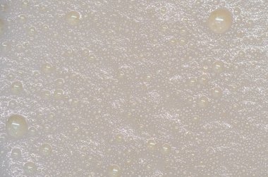 Süt köpüğü yüzeyinde kabarcıklar. Süt köpüğünün detaylı dokusu. Soyut arkaplan, duvar kağıdı