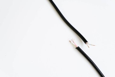 Beyaz arka planda bakır çekirdekli yırtık bir kablonun iki ucu. Bozuk kablo tamir gerektiriyor. Bağlantıyı kes