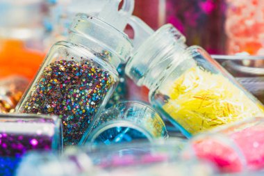 Çeşitli simlerle dolu küçük cam kavanozlar. Çok renkli simli kavanozlar. Canlı renkler ve parlak dokular. Sanat, el sanatları, dekorasyon, yaratıcılık kavramları