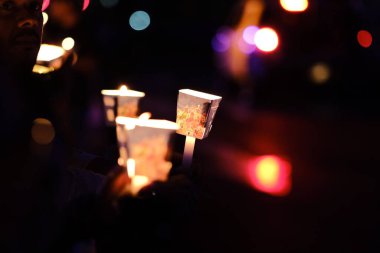 Farklı renkte insanlar kalabalığın önünde duruyorlar..