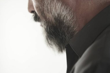 Yakın plan. Gri arka planda sakallı ve bıyıklı adam. Adamın sakalı ve bıyığı, sakalı ve saçı. erkek moda konsepti.