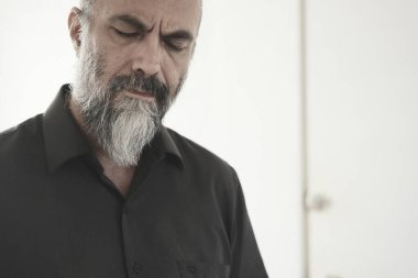 Beyaz gömlekli, sakallı ve bıyıklı son sınıf öğrencisinin portresi..