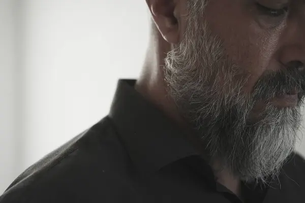 Odada sakallı ve siyah sakallı bir adam var.