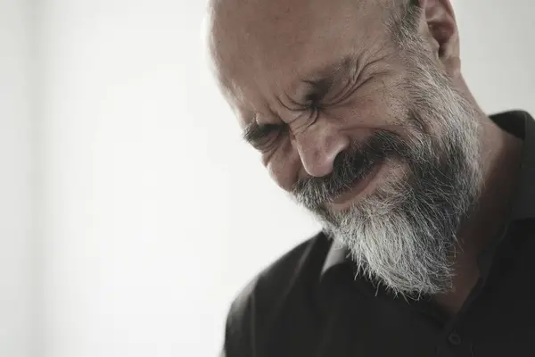 Sakallı, siyah gömlekli yaşlı adam..