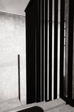 Bir çitin minimalist kompozisyonu ve gölgesi, mimarisi ve zaman geçişi.