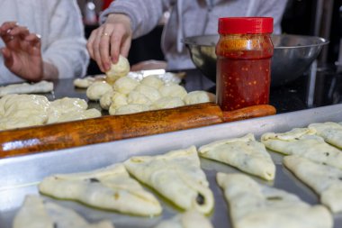 Geleneksel Arap hamur işlerini hazırlamak için dişilerin elleriyle ıspanak ve kırmızı biber dolduruyorlar.