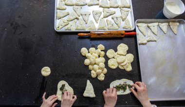 Anne ve kızı birlikte çalışıyorlar. Akşam yemeği için pasta hazırlıyorlar.