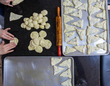 Anne ve kızı birlikte çalışıyorlar. Akşam yemeği için pasta hazırlıyorlar.