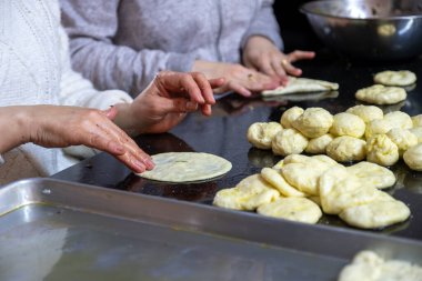 Geleneksel Arap hamur işlerini hazırlamak için dişilerin elleriyle ıspanak ve kırmızı biber dolduruyorlar.