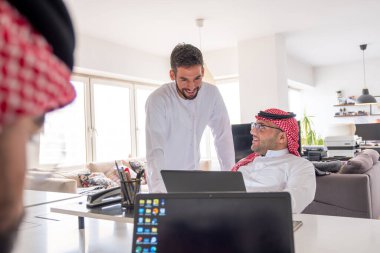 Görevdeyken projeyi bitirmek için toplantı masasında dizüstü bilgisayar kullanan Arapça