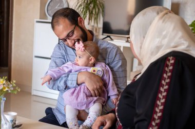 Baba kucağında yeni doğmuş bebek gülümseyen ve kameraya bakan heyecanlı ve sevgi dolu