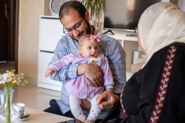 Baba kucağında yeni doğmuş bebek gülümseyen ve kameraya bakan heyecanlı ve sevgi dolu