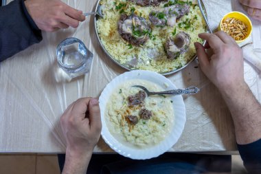 Aile iftar için akşam yemeğinde mansaf yiyor.