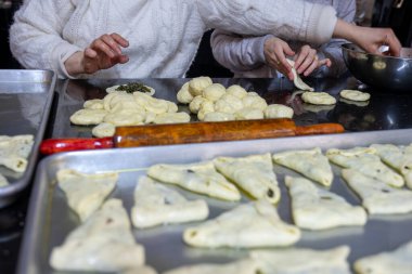 Geleneksel Arap hamur işlerini hazırlamak için dişilerin elleriyle ıspanak ve kırmızı biber dolduruyorlar.