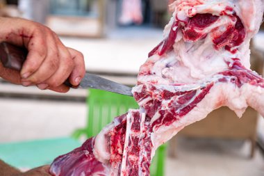 Kasap eti ahşap tahtada bıçakla keser. Springfield 'da şefin bıçağıyla yakın plan çiğ et.