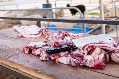 Kasap eti ahşap tahtada bıçakla keser. Arka planda koyun ahırı olan Springfield 'da şefin bıçağıyla yakın plan çiğ et parçası.