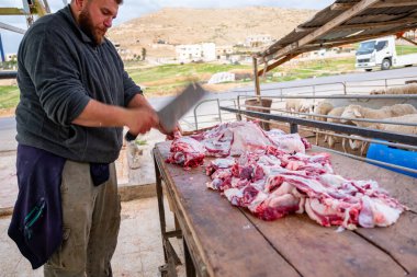 Kurban Bayramı 'nda ihtiyacı olan Müslümanlara dağıtılmak üzere koyunları budayıp kesen Müslüman adamlar.