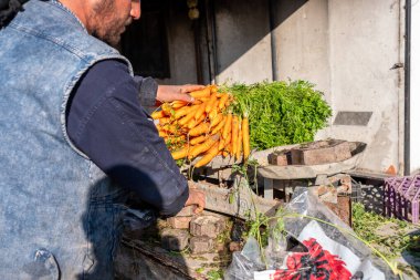 Geleneksel pazar yeri olan güneş ışığı altında müşteriye satılmak için eski pulları kullanarak havuç beyazlatma