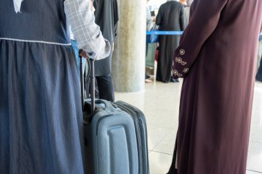 İnsanlar havaalanı bekleme kuyruğunda ellerini tutuyorlar.