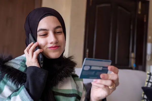 Müslüman kadın tesettürlü telefon kullanarak müşteri hizmetlerine başvuruyor.