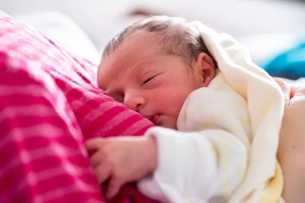 stock image mother cuddling her newborn with smile on their faces and adorable look on baby face