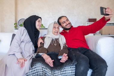 Arap ailesi, modern evde büyükanneleriyle selfie çekiyor.