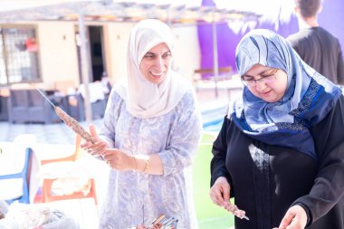 Kadınlar sadece tatillerinde birbirlerine yardım ederler. Barbeküyü de hazırlarlar.