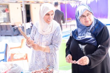 Kadınlar sadece tatillerinde birbirlerine yardım ederler. Barbeküyü de hazırlarlar.