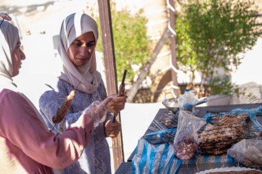 Kadınlar sadece tatillerinde birbirlerine yardım ederler. Barbeküyü de hazırlarlar.