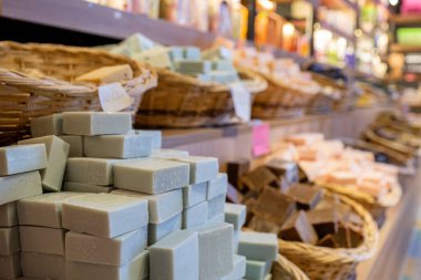 Bir mağazada el yapımı yeşil sabun dolu sepet ahşap arka planda vücut bakım ürünlerinden oluşur.