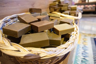 Bir mağazada el yapımı Laurel sabunu dolu el yapımı sepet ahşap arka planda vücut bakım ürünlerinden oluşur.