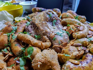 Üst görünüm işkembe, boşluklar, limonlu bacaklar ve siyah arka planda bitkiler yenmeye hazır.