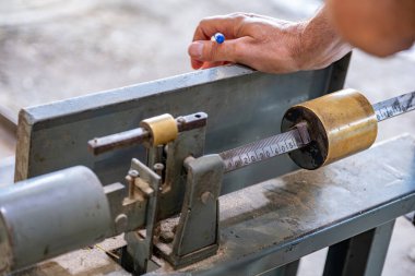 Adam dolma kalemi terazinin önünde tartıyor, zeytin torbaları tartıyor.