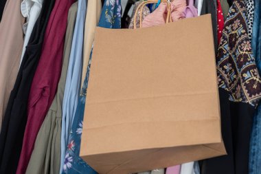 Gardırobun içinde elbise askısı olan siyah cuma alışveriş torbası.