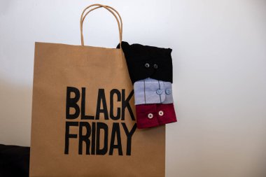 Shirt sleeve with shopping bag represents clothes sales for black friday and white friday with mock up space or free space clipart