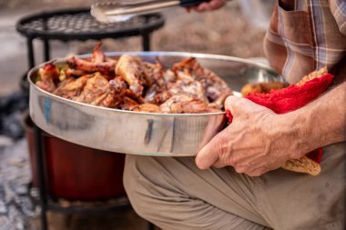 old man hands who is grandfather is moving zurbian dinner to be served on dinner table clipart