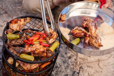 Zurbian dinner. The barrel has been uncovered and it is ready and well cooked. It contains chicken, vegetables and rice. It is placed on a wire rack and it has been transferred to the serving tray. clipart