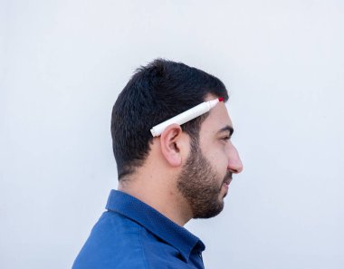 Beyaz arka planda elinde kalem tutan ve öğretmenlik yapan genç bir erkek.